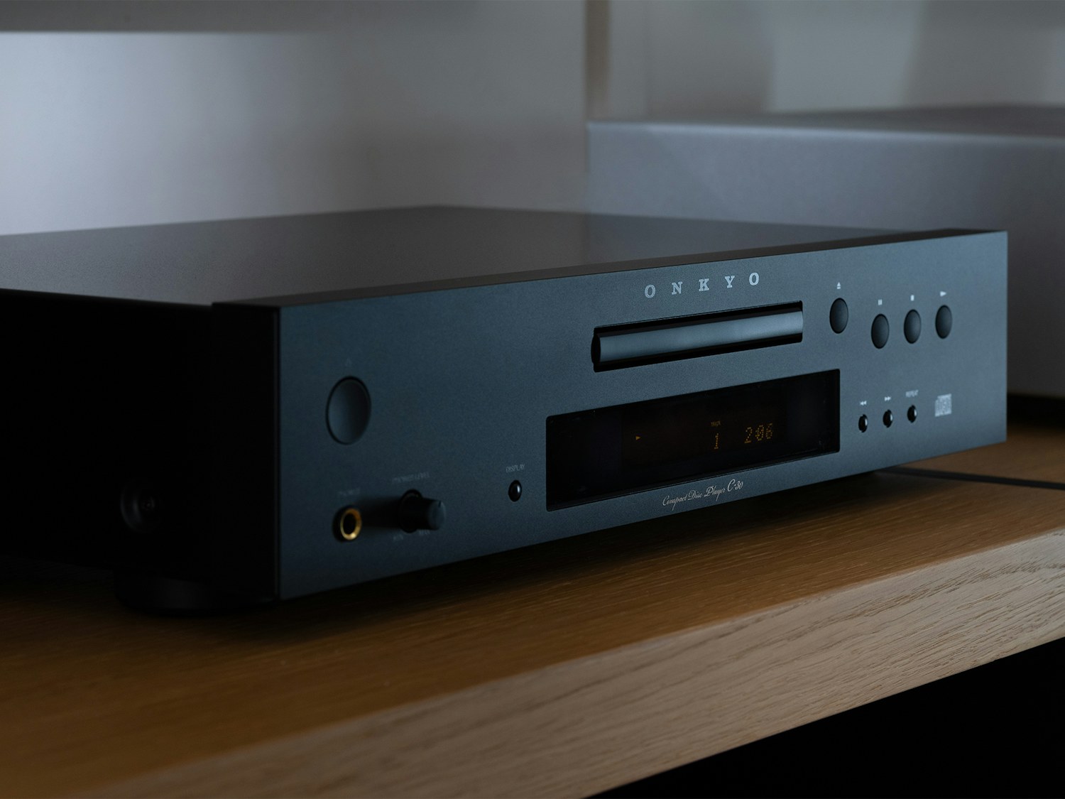 Onkyo C 30 CD Player angled closeup on wood shelf in moody light 2000x1500