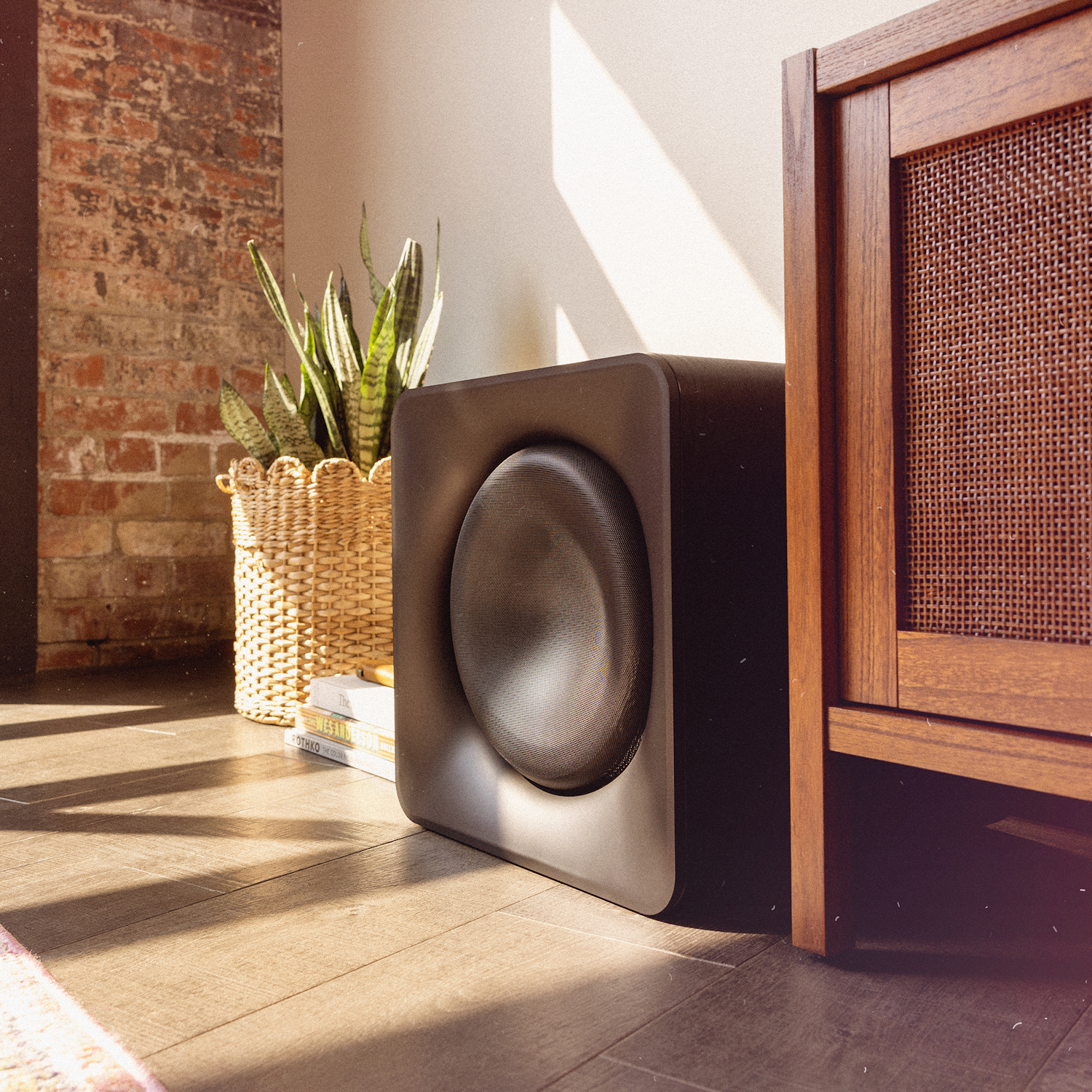Klipsch Flexus SUB 200 in sunny living room beside snake plant in basket and media console 2000x2000