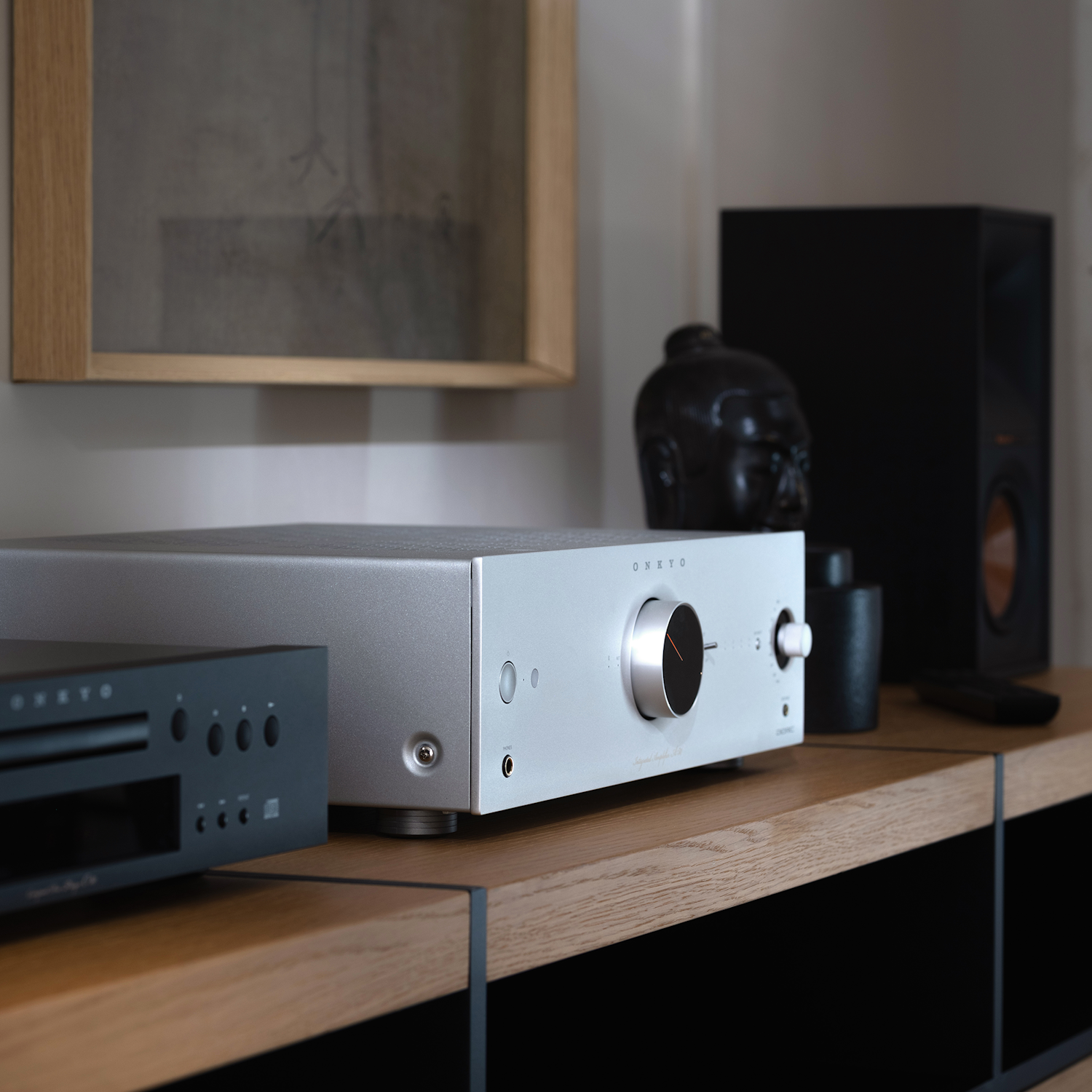 Onkyo Icon A 50 silver angled beside Klipsch bookshelf speaker and light art on wall 2000x2000